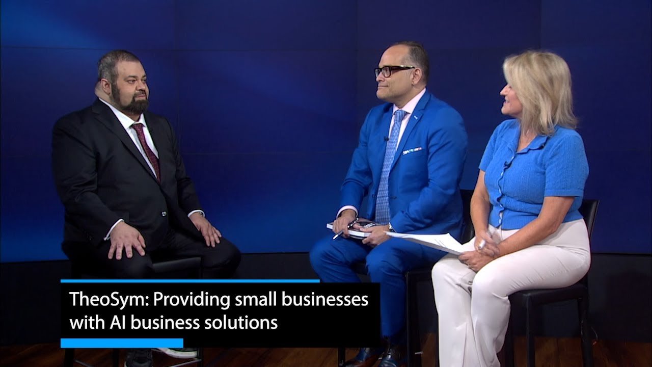 Sam Sammane in a TV studio interview; the lower third reads TheoSym: Providing small businesses with AI business solutions